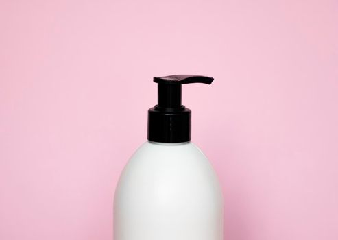 White plastic soap dispenser pump bottle isolated on pink background. Skin care lotion. Bathing essential product. Shampoo bottle. Bath and body lotion. Fine liquid hand wash. Bathroom accessories