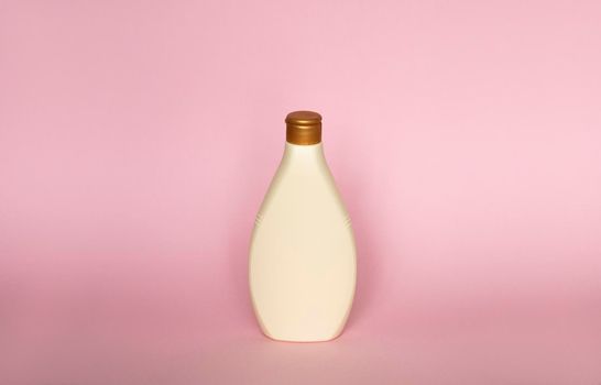 Beige plastic soap or shampoo bottle isolated on pink background. Skin care lotion. Bathing essential product. Shampoo bottle. Bath and body lotion. Fine liquid hand wash. Bathroom accessories