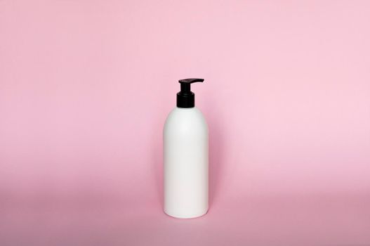 White plastic soap dispenser pump bottle isolated on pink background. Skin care lotion. Bathing essential product. Shampoo bottle. Bath and body lotion. Fine liquid hand wash. Bathroom accessories