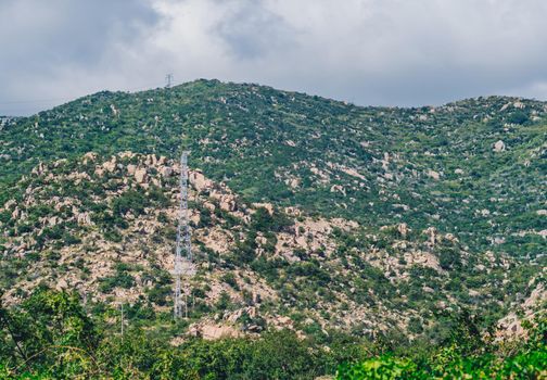 BANNER Green forest rocky mountain overlooking beautiful nature landscape. Cumulus dramatic stormy clouds. High-voltage poles, electricity energy in remote wild places planet.