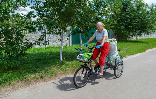 An old woman rides a bicycle. Selection focus. Nature.