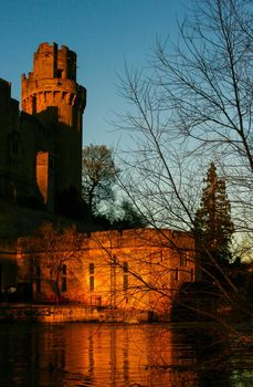 Ancient European medieval architectural building castle in golden autumn light with the blue sky background during autumn
