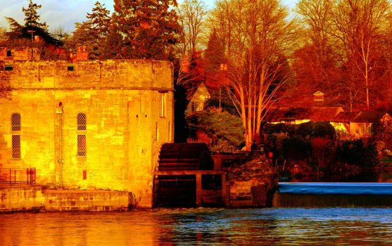 Ancient European medieval architectural building castle in golden autumn light with the blue sky background during autumn