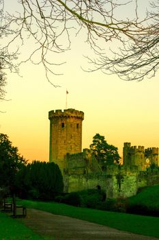 Ancient European medieval architectural building castle in golden autumn light with the blue sky background during autumn