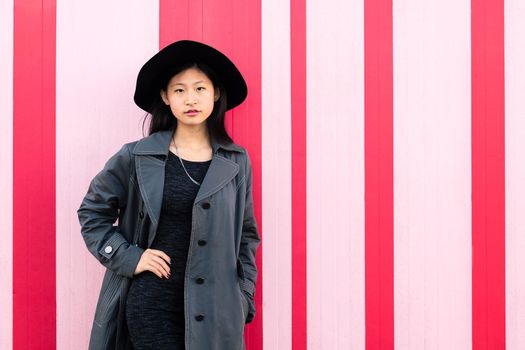 young beautiful classy asian girl posing in a pink background, concept of elegance and fashion lifestyle, copy space for text