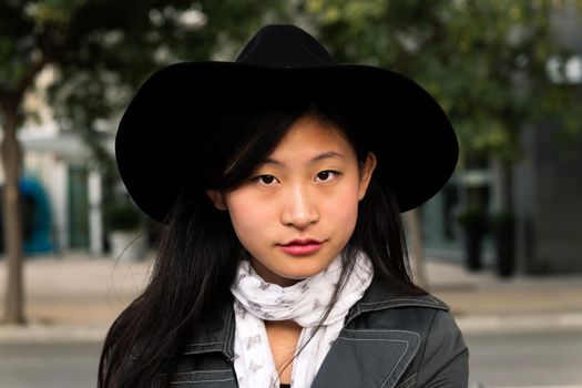 portrait of a beautiful and elegant young asian woman with hat, concept of elegance and urban lifestyle