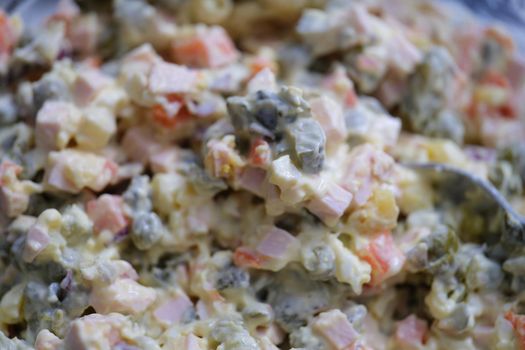 Olivier salad and food ingredients green peas cucumber potatoes sausage and mayonnaise. Delicious fresh traditional salad olivier concept