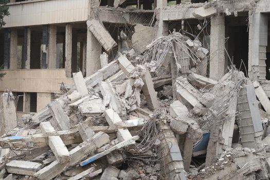 Industrial concrete building destroyed by an earthquake. Disaster war debris dust and destroyed buildings concept
