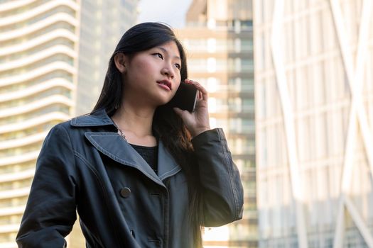 classy young asian woman talking on mobile phone in the city, technology and urban lifestyle concept, copy space for text