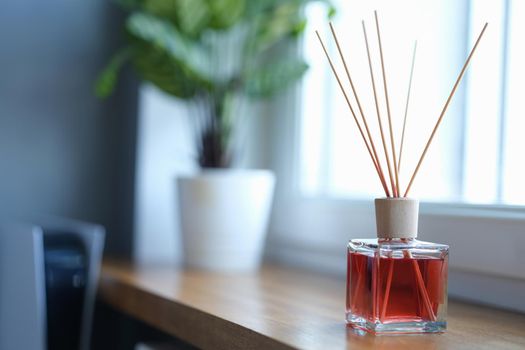 Reed air freshener on a wooden window sill indoors. Essential oils natural fragrance for home concept