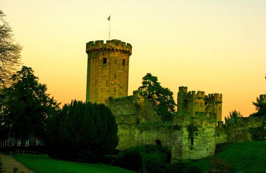 Ancient European medieval architectural building castle in golden autumn light with the blue sky background during autumn
