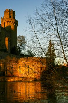 Ancient European medieval architectural building castle in golden autumn light with the blue sky background during autumn
