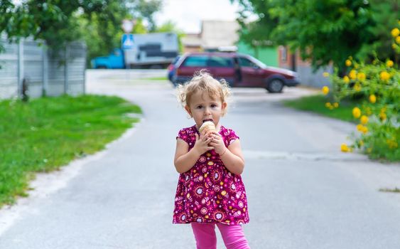 The child eats ice cream on the street. Selective focus. Food.