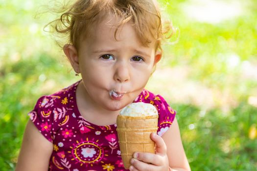 The child eats ice cream on the street. Selective focus. Food.