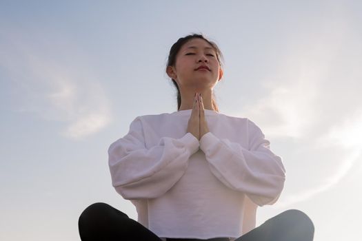 portrait of a young asian woman sitting meditating in the morning, relaxation and mental health concept, copyspace for text