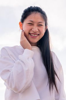young asian woman dressed in white laughing happy and funny, concept of youth and healthy lifestyle