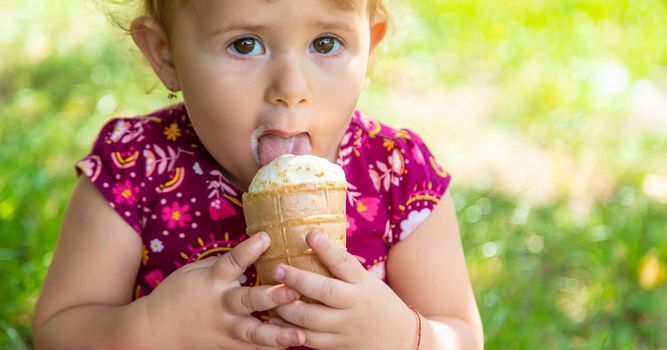 The child eats ice cream on the street. Selective focus. Food.