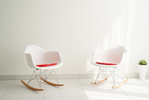 Modern light and airy interior. White room with chairs and empty background wall