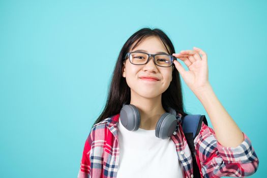 Happy Student. Cheerful Asian Girl Smiling To Camera Standing With Backpack In Studio Over Blue Background. Back to school concept.