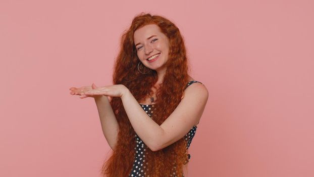 Cheerful rich redhead woman showing wasting or throwing money around hand gesture, more tips dreaming about big profit body language. Young freckles cute girl posing isolated on pink studio background