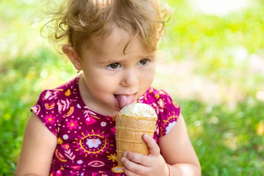 The child eats ice cream on the street. Selective focus. Food.