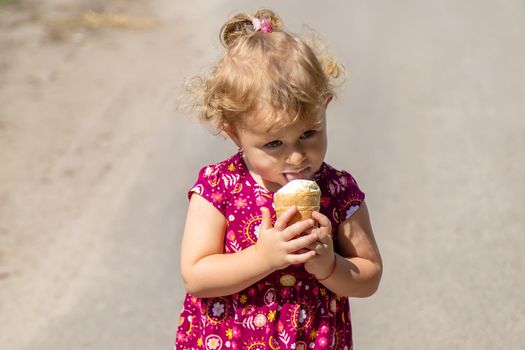 The child eats ice cream on the street. Selective focus. Food.