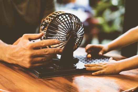 Two people Man adult boy hands caucasian skin together play loto board game. Lotto round sphere spins small orange balls. Vintage matte light brown effect. Upbringing. Education.