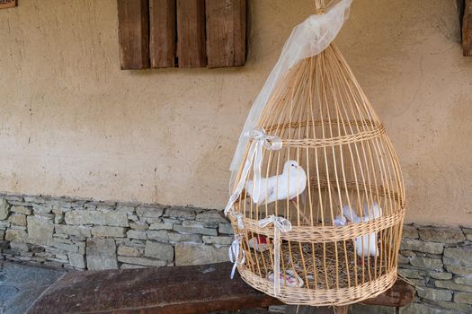 Replica of a historical cage. Two white pigeons in an intertwined cage