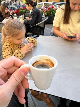 Cup of coffee in a man hand at a table in a restaurant. High quality photo