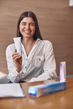 Happy beautiful caucasian woman with toothpaste in modern clinic's reception