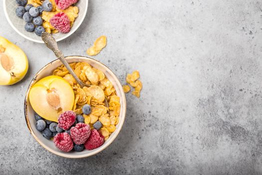 Healthy breakfast bowl, cereals, fresh fruit, berries on table. Clean eating, diet concept. Top view. Healthy bowl with cereals, raspberries, blueberries, plum. Space for text. Selective focus.