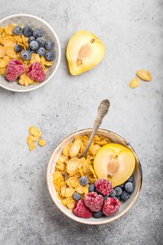 Healthy breakfast bowl, cereals, fresh fruit, berries on table. Clean eating, diet concept. Top view. Healthy bowl with cereals, raspberries, blueberries, plum. Granola. Vegetarian. Selective focus.