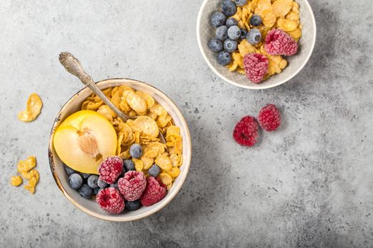 Healthy breakfast bowl, cereals, fresh fruit, berries on table. Clean eating, diet concept. Top view. Healthy bowl with cereals, raspberries, blueberries, plum. Space for text. Selective focus.