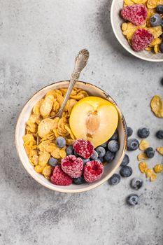 Healthy breakfast bowl, cereals, fresh fruit, berries on table. Clean eating, diet concept. Top view. Healthy bowl with cereals, raspberries, blueberries, plum. Granola. Vegetarian. Selective focus.