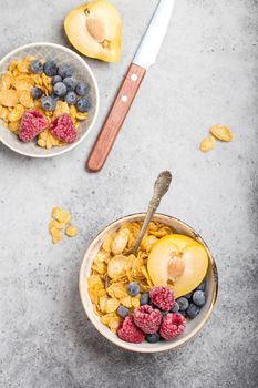 Healthy breakfast bowl, cereals, fresh fruit, berries on table. Clean eating, diet concept. Top view. Healthy bowl with cereals, raspberries, blueberries, plum. Granola. Vegetarian. Selective focus.