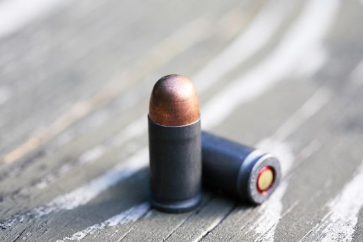 Handgun cartridges closeup on old wooden background
