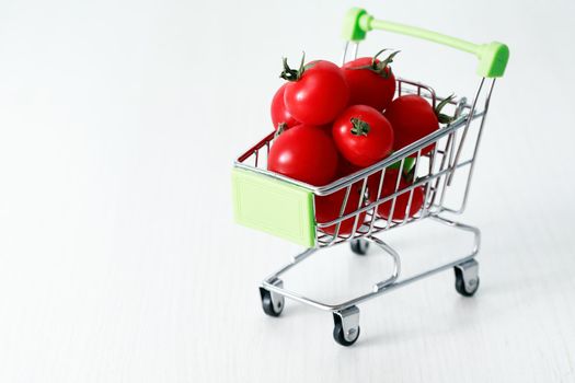 Healthy eating concept. Shopping cart with red freshness tomatoes