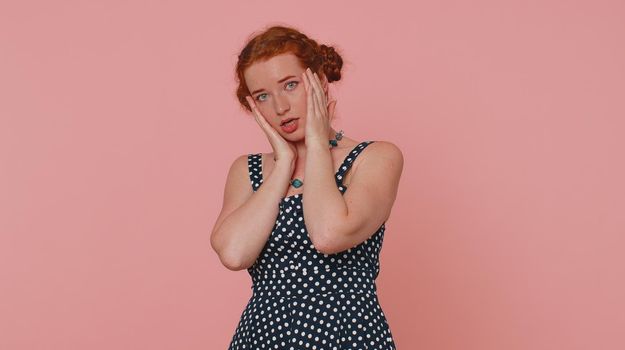 Woman feeling hopelessness and loneliness, nervous breakdown, loses becoming surprised by lottery results, bad fortune, loss, unlucky news. Ginger girl with freckles isolated on pink studio background