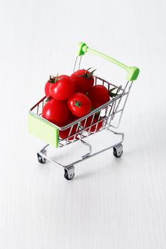 Healthy eating concept. Shopping cart with red freshness tomatoes