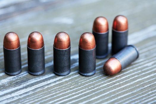 Handgun cartridges closeup on old wooden background