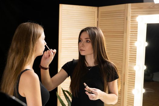 Proffesional makeup artist apply makeup to the beautiful model face. Beauty fashion model
