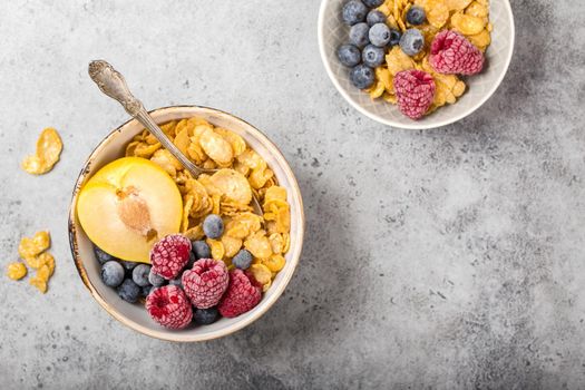 Healthy breakfast bowl, cereals, fresh fruit, berries on table. Clean eating, diet concept. Top view. Healthy bowl with cereals, raspberries, blueberries, plum. Space for text. Selective focus.