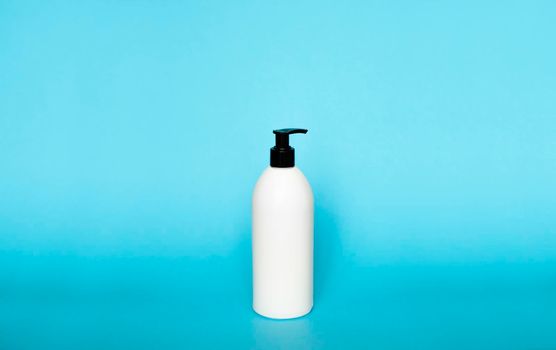 White plastic soap dispenser pump bottle isolated on blue background. Skin care lotion. Bathing essential product. Shampoo bottle. Bath and body lotion. Fine liquid hand wash. Bathroom accessories