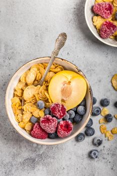 Healthy breakfast bowl, cereals, fresh fruit, berries on table. Clean eating, diet concept. Top view. Healthy bowl with cereals, raspberries, blueberries, plum. Granola. Vegetarian. Selective focus.