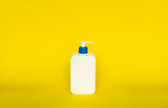 White plastic soap or shampoo dispenser pump bottle isolated on blue background. Skin care lotion. Bathing essential product. Shampoo bottle. Bath and body lotion. Fine liquid hand wash