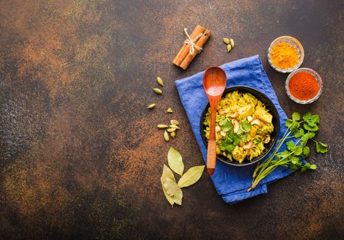 Biryani rice, traditional Indian dish. Biryani spicy rice, chicken, nuts. Indian rice bowl, spices, herbs, rustic stone background. Top view. Space for text. Asian style biryani rice. Indian dinner