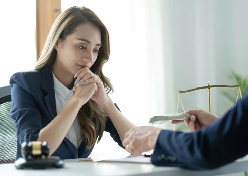 A professional asian female lawyer or business legal consultant having a secret meeting with her client and receives a bribe. cropped shot.