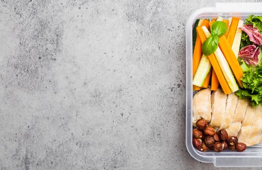 Healthy food lunchbox for office or school: chicken fillet, carrot, cucumber sticks, salad. Preparation and packaging of meal to support balanced lifestyle or diet, stone background, copy space