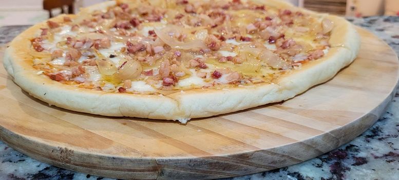 homemade homemade pizza with pasta made with a family recipe and stuffed with bacon, onion, cheese and sauce, great for a family weekend