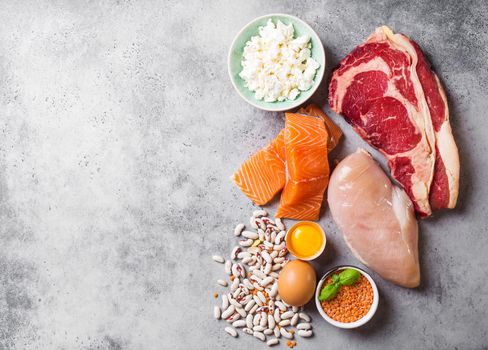 Assortment of natural sources of protein from food: meat, fish, chicken, dairy products, eggs, beans. Diet, healthy eating, wellness, bodybuilding concept, top view, space for text.